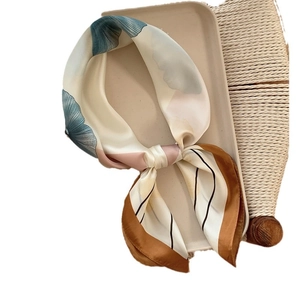 Elegant silk printed square scarf with floral pattern displayed on a minimalist tray