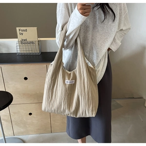 Detailansicht beige Tragetasche mit Faltenstruktur und KISS YOURSELF Stoffaufnäher