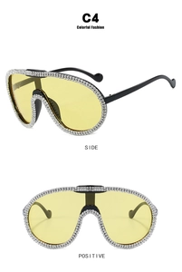 Detail view of rhinestone-encrusted frames and yellow lenses on oversized cycling sunglasses