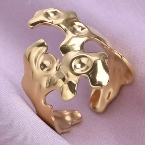 Macro shot of 18K gold plated lava style irregular ring on purple satin fabric