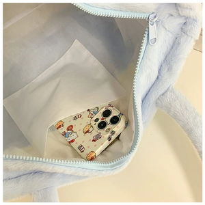 Detail view of plush tote bag interior with white lining, inner pocket and nylon zipper