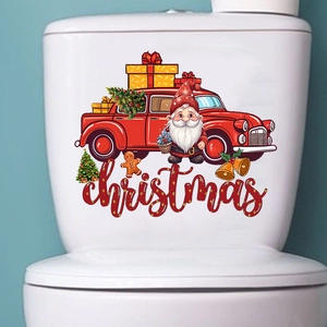 Close-up of festive Christmas truck and Santa wall stickers on a white ceramic toilet tank