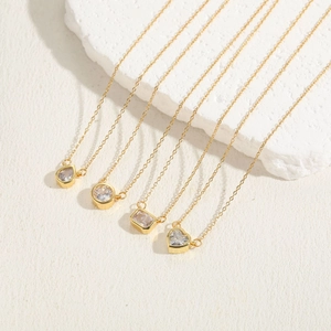 Close-up of four gold necklaces with crystal heart, round, drop and rectangle pendants