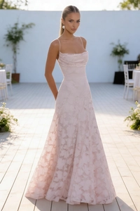 Detailed close-up of light pink jacquard fabric texture on a long spaghetti strap dress
