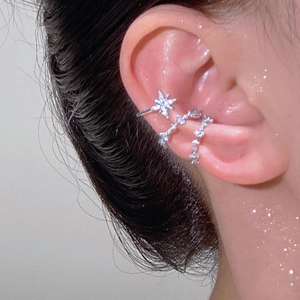 Nahaufnahme von silbernen Earcuffs mit Sternen und Zirkonia für Ohren ohne Löcher