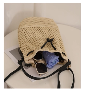 Detail of straw bucket bag interior showing capacity for sunglasses and accessories
