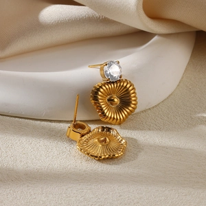 Detailed close-up of heart zircon pearl earrings with pleated gold metal textures