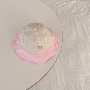 Detail of baby sun hat with pink peach embroidery and wavy scalloped brim texture
