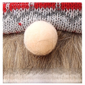 Detailed close-up of knitted Christmas gnome wine bottle cover with nose and beard