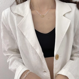 Detailed view of silver necklace and bracelet set with gold interlocking CD pendant charms