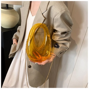 Fashionable yellow acrylic evening box bag with gold chain strap shown on model's arm