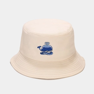 Dettaglio di un cappello da pescatore crema in cotone con ricamo di piccola balena