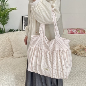 Detail of white canvas tote bag with pink polka dots and ruched drawstring closure