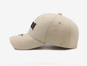 Detail view of khaki cotton baseball cap featuring high-density 3D letter embroidery