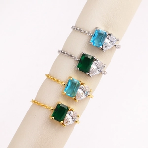 Detailed view of chain rings with emerald-cut zircon in gold and silver plating