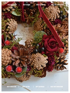 Macro shot of rustic Christmas wreath with red silk roses, pine cones and berries