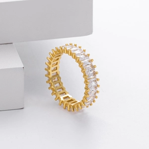 Macro shot of gold eternity ring featuring channel-set rectangular clear cubic zirconia stones