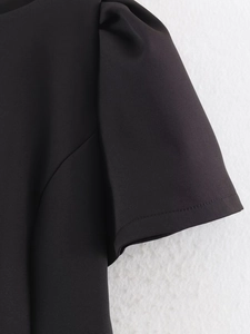 Close-up of black puff sleeve detail with fine stitching on a trendy short dress