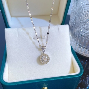 Detailed close-up of a silver roman numeral necklace with zircon in a green box