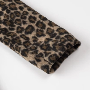 Macro detail of the sleeve cuff on a vintage leopard print blazer with thick fabric texture