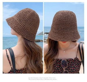 Detail of brown woven straw bucket hat showing sun protection brim on a sunny beach