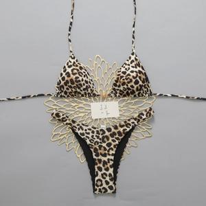 Detail of leopard print bikini with halter neck straps and golden sun buckle ornament