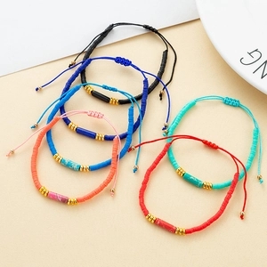 Makroaufnahme bunter Bohemian-Armbänder mit Natursteinperlen und goldenen Akzenten am Verschluss