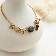 Detailed view of handmade stainless steel necklace with gold discs and natural grey stone bead