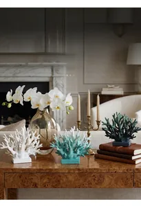 Artistic resin coral sculptures in white, teal, and blue on stable square bases