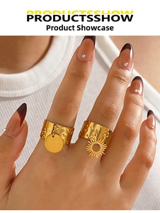 Close-up of 18K gold plated hammered texture rings with sun and disk charms on a hand