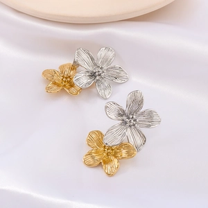 Two-tone gold and silver flower earrings on white silk fabric, floral titanium jewelry