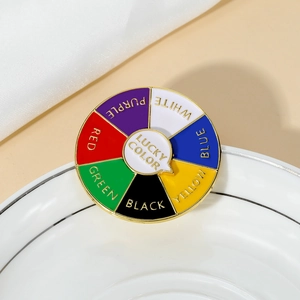 Vue macro d'une broche émaillée en forme de roue de couleurs chanceuses dorée