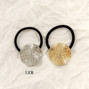 Detail of 3.5cm gold and silver hollow metal hair ties with etched geometric textures