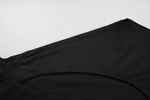 Detail of cutout design and stitching on double-layered black long-sleeve dress