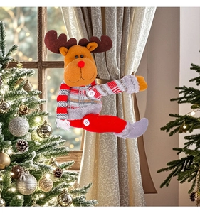 Detail of plush reindeer curtain buckle with knitted fabric on a Christmas tree background