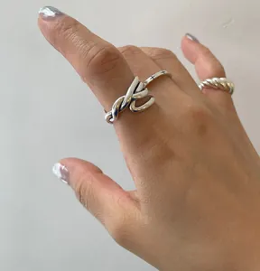 Close-up of 925 sterling silver rings with twisted geometric lines and polished finish