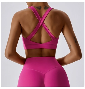 Dettaglio del set yoga rosa con reggiseno sportivo incrociato e leggings a vita alta a V