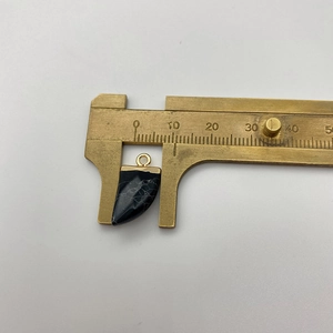 Measuring a black marble stone tooth pendant with calipers for 20mm jewelry sizing