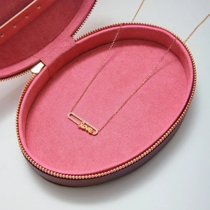 Dettaglio macro della collana a spilla LOVE in oro rosa con zirconi in una scatola regalo