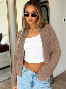 Brown long-sleeved knit cardigan paired with a white tube top and blue denim jeans