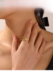 Macro detail of 18K gold plated X-shaped criss-cross ring with twisted rope texture