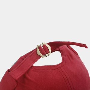 Detailed close-up of dark red canvas beanie with vintage bronze adjustable metal buckle