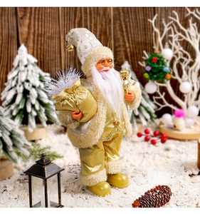 Detail of Santa Claus figurine with golden outfit and pink beard in a winter setting