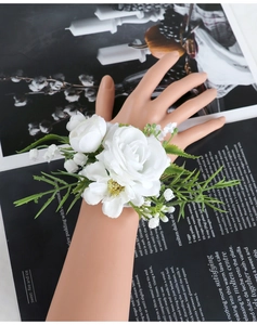 Detailed view of bridal white rose and lily of the valley wrist corsage for weddings
