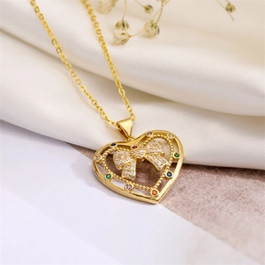 Detail of gold heart pendant with crystal bow and colorful rhinestones on a necklace