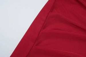 Detailed macro view of the red mesh fabric texture and stitching of the slim bodycon dress