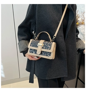 Close-up of leopard print handbag with gold hardware worn with a grey wool coat