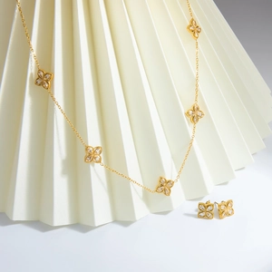 Golden clover jewelry set with necklace and earrings featuring sparkling crystals