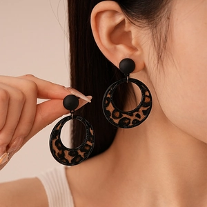 Detailed view of leopard print flocking earrings with matte black sphere stud