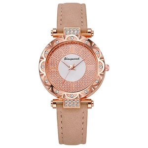 Detail of rose gold quartz watch featuring rhinestone bezel and nude pink leather strap